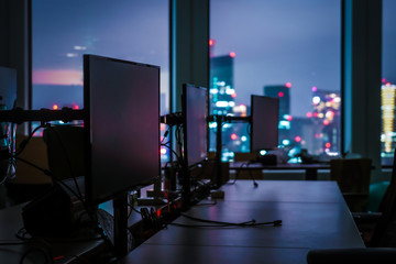 夜のオフィスと東京の街並み