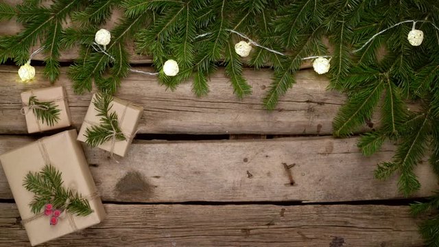 Christmas frame made of fir branches with gift boxes on white planks