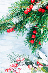 Christmas wooden background with spruce branches and red berries