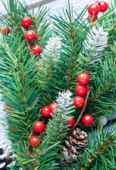 Christmas wooden background with spruce branches and red berries