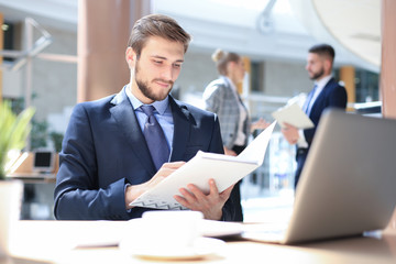 Portrait of young man sitting at his desk in the office.