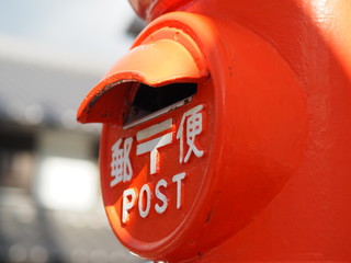 古い円柱型郵便ポストの投函口のクローズアップ