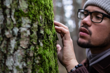 Man in a forest near a tree 