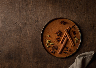 set of spices, cinnamon, cardamom, star anise, cloves. wooden background, top view, copy space