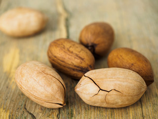 A few necanone nuts in a cracked shell. Nuts on a wooden surface