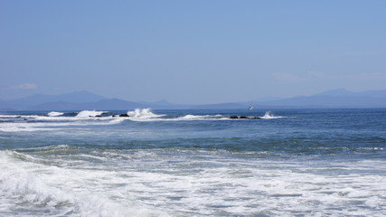 Naklejka na ściany i meble Big waves on the sea of ​​Japan. Boat in the distance