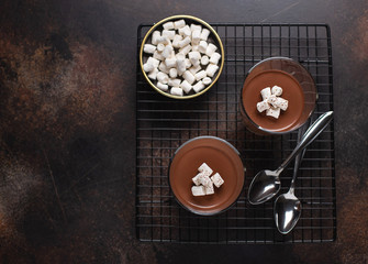 chocolate panna cotta with marshmallows. brown monochrome. dark textured background, copy space, top view