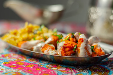 Pieces of cooked marinated chicken breast in an onion and tomato sauce with yogurt and mint and crispy fried onions layered with spiced basmati rice