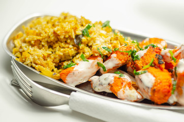 Pieces of cooked marinated chicken breast in an onion and tomato sauce with yogurt and mint and crispy fried onions layered with spiced basmati rice