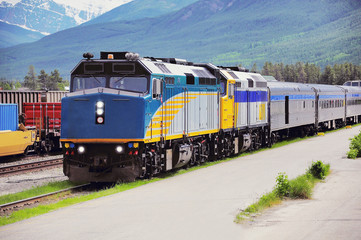Passenger train from Vancouver stands at Jasper station platform after arrival. Alberta.