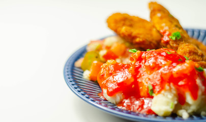 Spicy chilli chicken fillets served with mashed potatoes and salad of tomatoes, cucumbers and onions