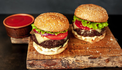 two Tasty grilled burgers on a stone background