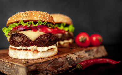 two Tasty grilled burgers on a stone background