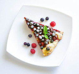 A piece of berry pie and fresh berries on a plate top view isolated