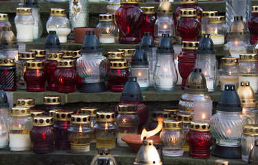 Monument and candles in the cemetery. All Saints Day in Poland. A lot of funeral candles.