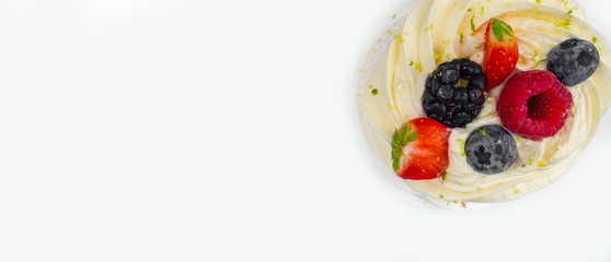 Meringue Pavlova with cream and fresh berries, strawberries, raspberries, blueberries isolated on white