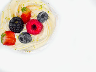 Meringue Pavlova with cream and fresh berries, strawberries, raspberries, blueberries isolated on white