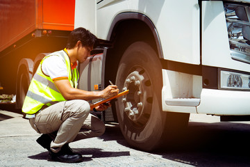 Truck driver inspecting safety daily checklist a truck tires