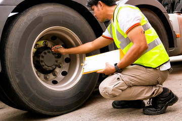 Truck driver inspecting safety daily checklist a truck tires