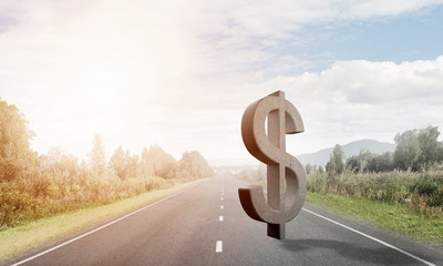 Money making and wealth concept presented by stone dollar symbol on asphalt road