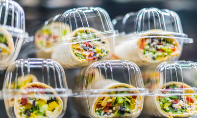 Pre-packaged sandwiches displayed in a commercial refrigerator