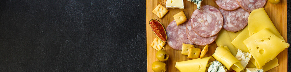 cheese board (different types of cheese plate appetizers , sausage, ham, olives, greens and more) menu concept. food background. copy space. Top view