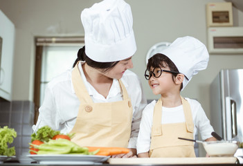 Happy family Asian woman young mother with son boy cooking healthy salad for the first time. first lesson and healthy lifestyle concept.