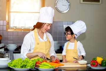 Happy family Asian woman young mother with son boy cooking healthy salad for the first time. first lesson and healthy lifestyle concept.