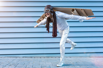 man in silver suit with glasses and aviator helmet and cardboard plane wings