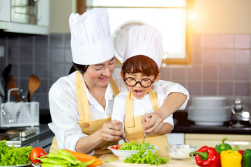 Happy family Asian woman young mother with son boy cooking healthy salad for the first time. first lesson and healthy lifestyle concept.
