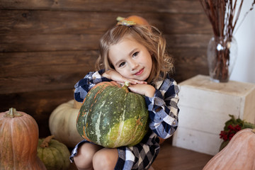 Fototapeta premium cute girl holding a pumpkin, autumn background