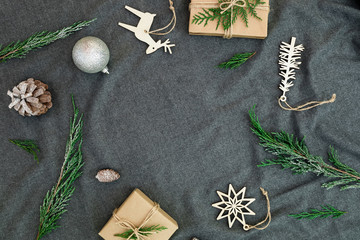 New Year frame concept. Christmas decorations with evergreen branches and gift boxes on dark. Flat lay, top view.
