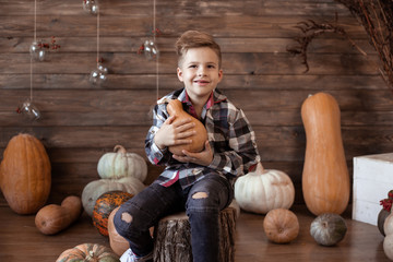 smiling child holding small pumpkin, autumn background