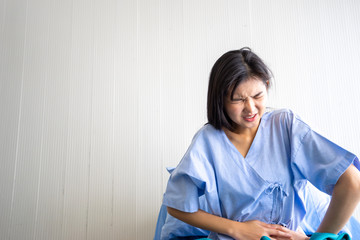 Naklejka premium Sick women stomach pain under the blanket. Sick woman infections with seasonal and allergy lying in bed. Sick woman covered with a blanket lying in bed with high fever.