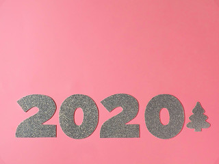 Celebrating the new year 2020. Silver mother-of-pearl paper, number 2020 with a Christmas tree on a...