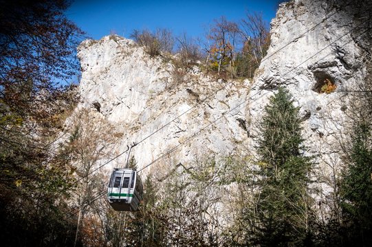 Cableway with blue sky and rocks background. Cable cabin in Moravia. Macocha Cable tramway. Translation of text in image: Macocha Cableway.
