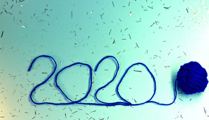 New Year 2020 blue festive background with thread tied with a blue ribbon. New Year 2020 concept. Selective focus, defocused view.