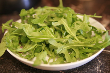 plate with fresh green arugula