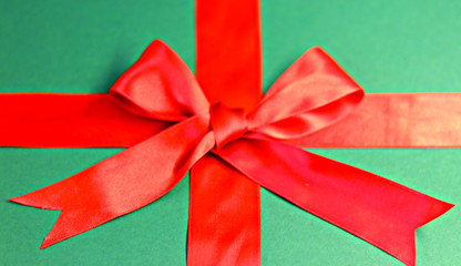  red ribbon with a bow with a tail on a green background. gift wrap