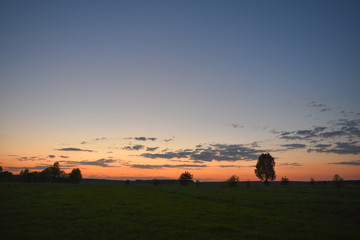 Fototapeta na wymiar Summer sunset over a mown field