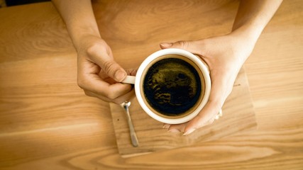 Fototapeta na wymiar An American coffee cup is held with two hands.