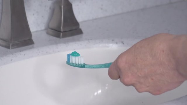 Putting toothpaste on a toothbrush - medium and close-up 4K