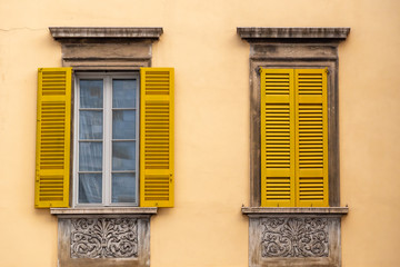 Fototapeta na wymiar windows with yellow shutters and walls, Europe