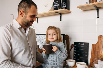 Little girl with her father in kitchen at home