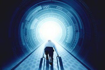 Back view of businessman in start running position in front of futuristic tunnel
