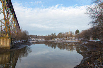 The 1908 railway trestle bridge and the 1859 St-Félix-de-Valois Church with their reflection in...