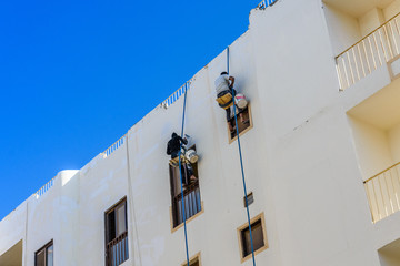 Fototapeta na wymiar Rope access workers on a residential building in Hurghada, Egypt