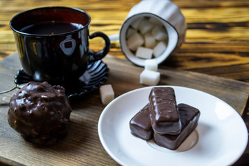 cup with tea near sugar bowl with tea and cookies