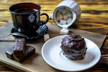 cup with tea near sugar bowl with tea and cookies