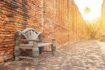 Vintage chair wooden and traditional red brick wall exterior wall with sunshine morning. Surface...